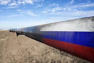 AN OIL PIPELINE SURROUNDED BY DIRT FADES INTO THE RUSSIAN FLAG.
