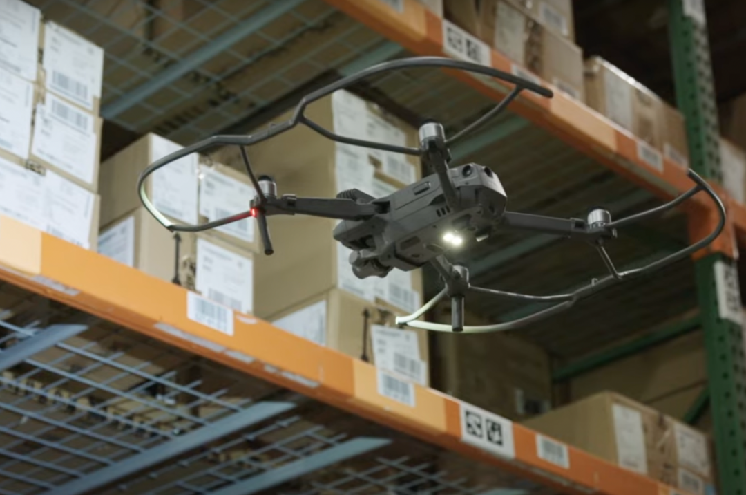 A DRONE HOVERS NEXT TO A WAREHOUSE SHELF