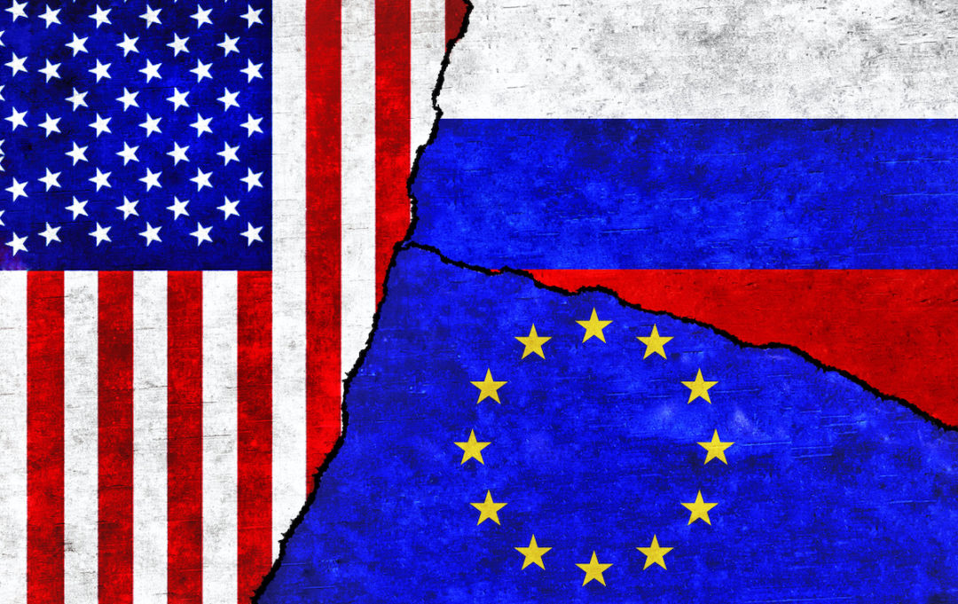 THE RUSSIAN, U.S. AND EU FLAGS ARE DIVIDED ON A TEXTURED WALL.