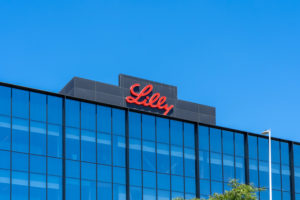 THE ELI LILLY LOGO CAN BE SEEN ON THE TOP OF A GLASS BUILDING.