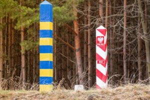 TWO STAKES IN THE GROUND BEAR THE COLORS OF UKRAINE AND POLAND'S FLAGS