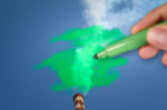 A PERSON WITH A GREEN MARKER COLORS IN THE SMOKE BILLOWING OUT OF THE TOP OF A SMOKESTACK.