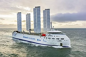 A LARGE SHIP SPORTS EIGHT TOWER-LIKE SAILS.