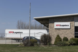 AN XPO LOGISTICS TRANSPORTATION CENTER HAS A PARKING LOT WITH AN XPO LOGISTICS TRAILER IN IT.