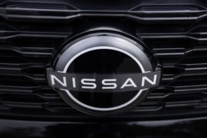 CLOSE-UP OF A NISSAN LOGO ON THE FRONT OF A CAR.
