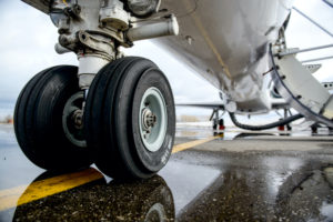 CLOSE-UP OF AN AIRPLANE'S LANDING GEAR ON THE TARMAC.