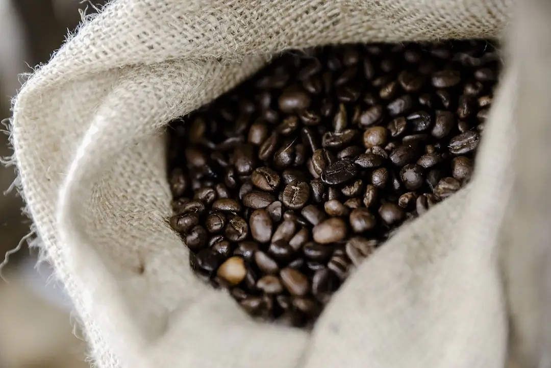COFFEE BEANS IN A WHITE SACK.