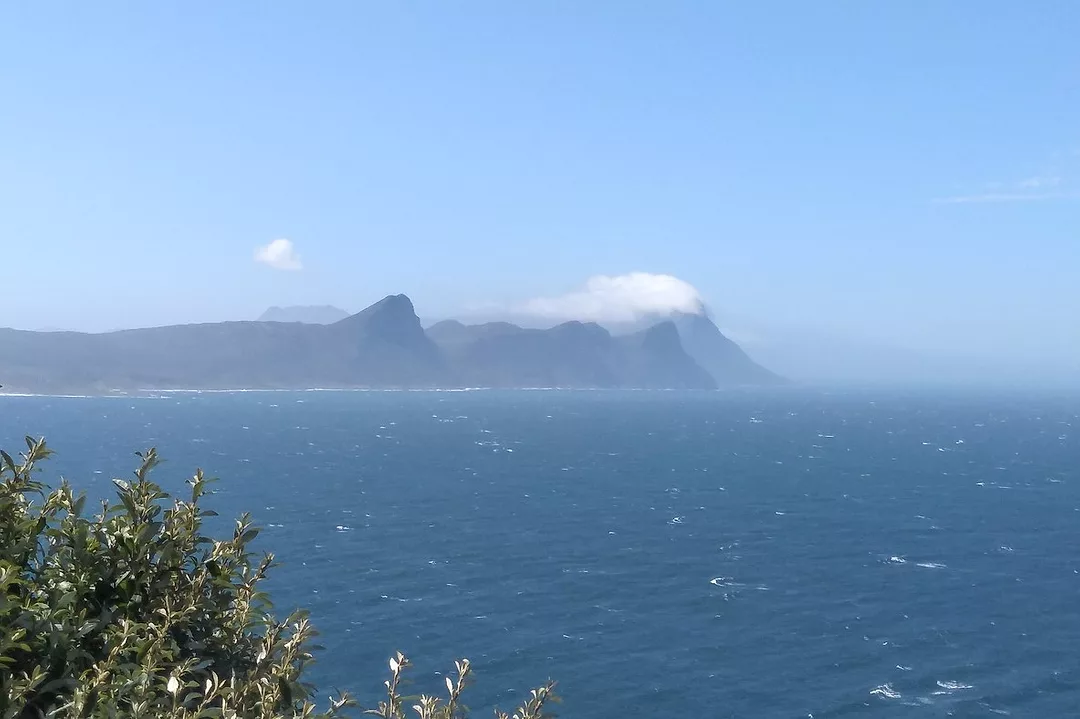 MOUNTAINS RISE OVER AN OCEAN.