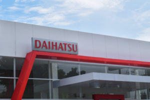 THE DAIHATSU LOGO CAN BE SEEN ON THE TOP OF A BUILDING.