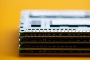 CLOSE-UP OF A SAMSUNG DOUBLE-DATA-RATE MEMORY MODULE IN FRONT OF A YELLOW BACKGROUND.