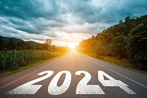 A ROAD SURROUNDED BY TREES LEADING TO A SUNSET IS LABELED "2024."