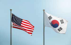 A U.S. FLAG WAVING IN THE WIND NEXT TO A SOUTH KOREAN FLAG.