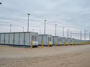 SEVERAL LARG LITHIUM-ION STORAGE BATTERIES UNDER A GRAY SKY.