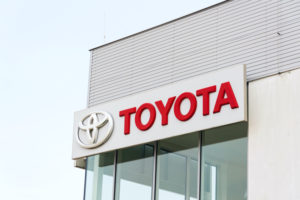 A TOYOTA MOTOR CORPORATION LOGO ON THE SIDE OF A CAR DEALERSHIP.