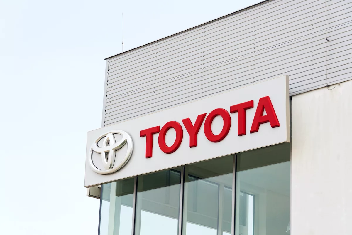 Bir araba galerisinin yanında duran Toyota Motor Corporation logosu