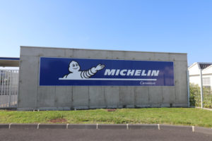 A LARGE CONCRETE WALL HAS THE MICHELIN LOGO ON IT.