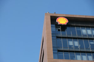 A SHELL PLC LOGO ON THE OUTSIDE OF A BROWN OFFICE BUILDING.