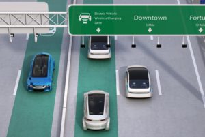 A GRAPHIC SHOWING A MULTI-LANE HIGHWAY, WITH ONE CAR DRIVING ON A LANE LABELED ELECTRIC VEHICLE WIRELESS CHARGING LANE