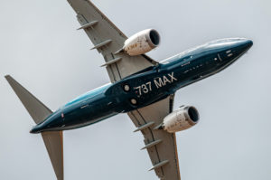 A BOEING MAX 737 JET FLYING THROUGH THE SKY. THE UNDERSIDE OF THE PLANE READS "737 MAX."