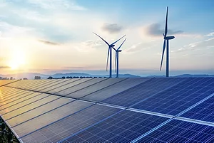 WIND TURBINES AND SOLAR PANELS UNDER A SETTING SUN.
