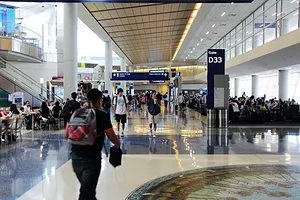 HUNDREDS OF PEOPLE CAN BE SEEN WALKING AROUND OR SITTING INSIDE OF THE DALLAS-FORT WORTH AIRPORT IN TEXAS.