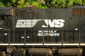 A WHITE NORFOLK SOUTHERN RAILWAY LOGO CAN BE SEEN ON THE SIDE OF A BLACK TRAIN.