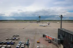 A PLAN BEARING THE LUFTHANSA LOGO SITS ON THE TARMAC OF AN AIRPORT