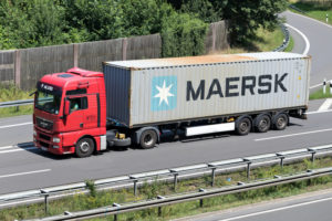 A MAERSK TRANSPORTATION TRUCK DRIVING ON A HIGHWAY.