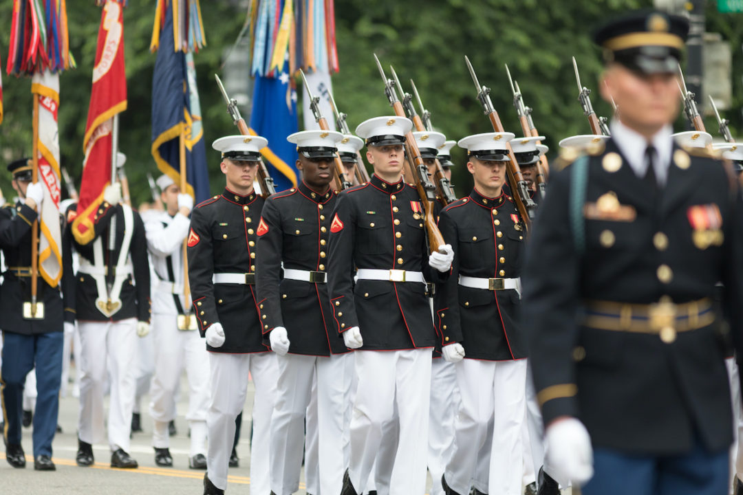 MEMBERS OF THE UNITED STATES MARINE CORPS MARCHING IN A PARADE.