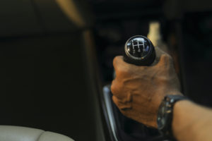 A PERSON'S HAND CAN BE SEEN ON THE GEAR STICK OF AN AUDI.