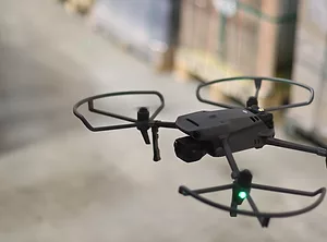 AN AUTONOMOUS MOBILE DRONE IN FLIGHT IN A WAREHOUSE.