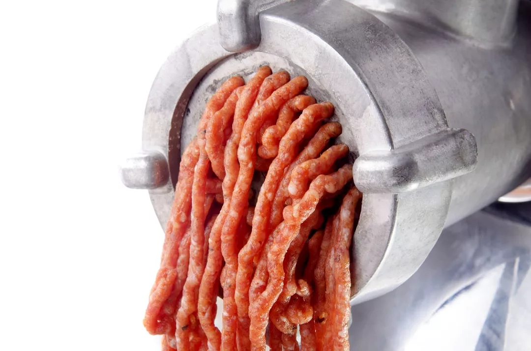 Minced meat comes out of a mincer 