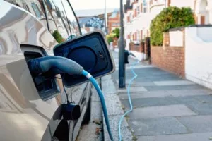 An electric car charges on a sunny day on a London street.