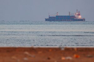 A CONTAINER SHIP AT SEA IS SEEN FROM THE SHORE