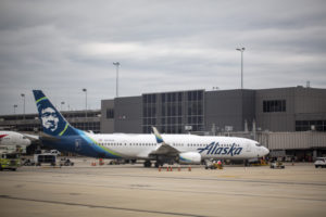 An Alaska Airlines 737 on the ground outside an airport terminal