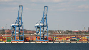 Cranes and shipping containers along the water at the Port of Baltimore.