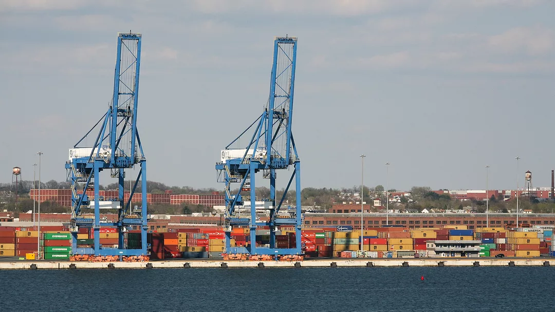 Cranes and shipping containers along the water at the Port of Baltimore.