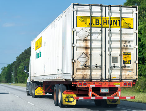 A J.B. Hunt truck seen from the back, driving down a road