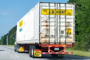 A J.B. Hunt truck seen from the back, driving down a road