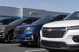 A row of General Motor trucks and SUVs outside of a dealership.