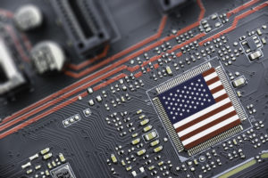 An American flag laid over a semiconductor chip