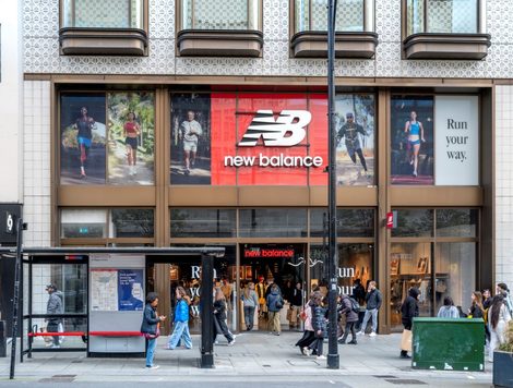 PEDESTRIANS WALK PAST THE ENTRANCE TO A NEW BALANCE STORE ON A BUSY CITY STREET