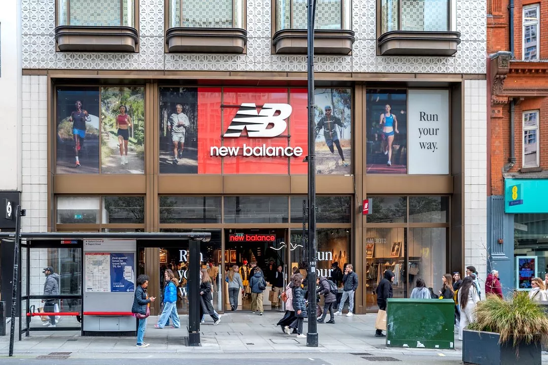 PEDESTRIANS WALK PAST THE ENTRANCE TO A NEW BALANCE STORE ON A BUSY CITY STREET