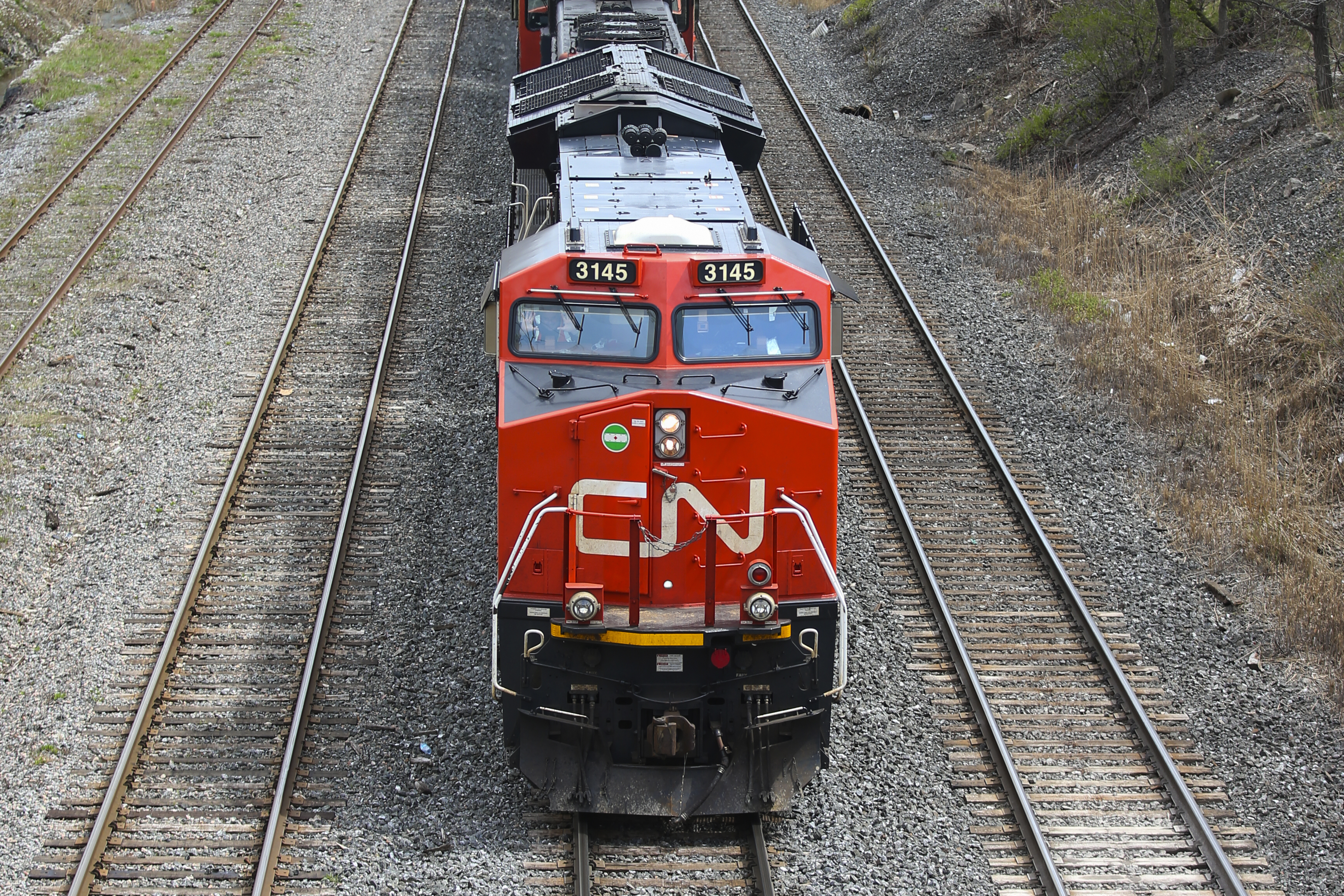 A red Canadian National Railway train moving on tracks 