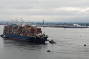 The Dali container ship being towed by tugboats through Baltimore's shipping channel