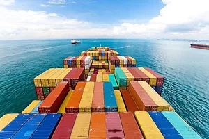 Horizontal wide angle view of heavy loaded container cargo ship in busy strait of Malacca