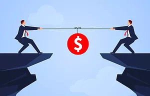 A CARTOON OF TWO MEN IN BUSINESS SUITS ENGAGED IN A TUG OF WAR OVER A BAG OF MONEY, ON THE EDGE OF A PRECIPICE