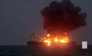 An oil tanker on fire, with smoke billowing into the sky