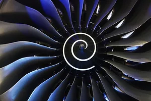 A close up of a turbine engine, with a white spiral pattern in the middle