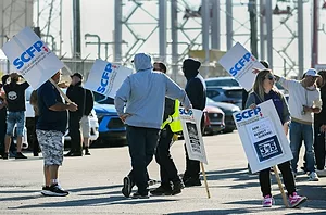 MULTIPLE PEOPLE IN HOODIES OUTDOORS HOLD SCFP PICKET SIGNS